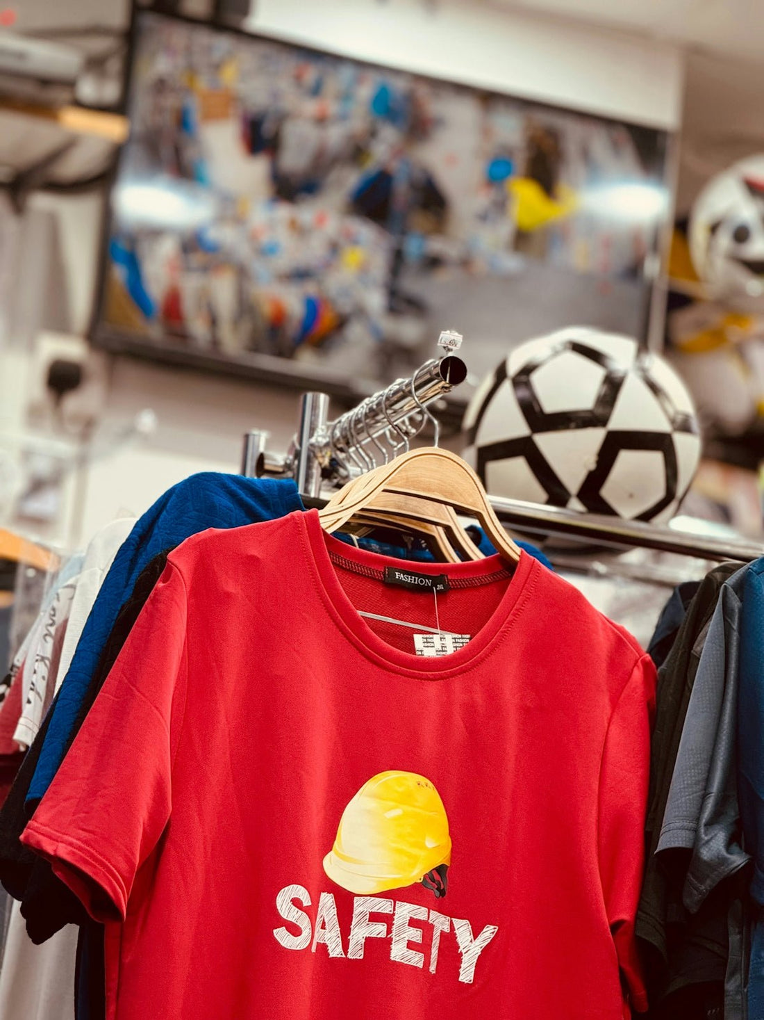 a red safety t - shirt hanging on a rack