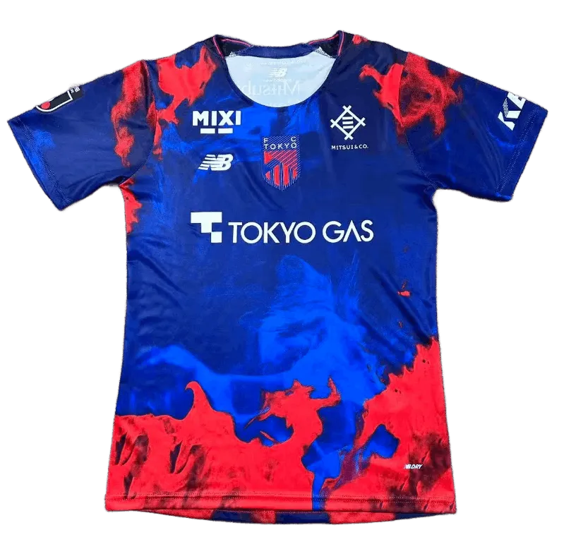 FC Tokyo jersey 2026 home front view deep blue shirt with red smoke graphics, central FC Tokyo crest, Tokyo Gas sponsor text, multiple chest sponsor marks, J.League sleeve patch