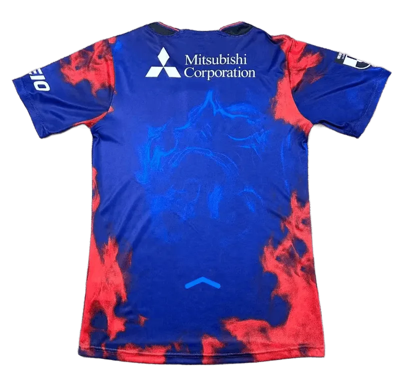 FC Tokyo jersey 2026 home front view deep blue shirt with red smoke graphics, central FC Tokyo crest, Tokyo Gas sponsor text, multiple chest sponsor marks, J.League sleeve patch