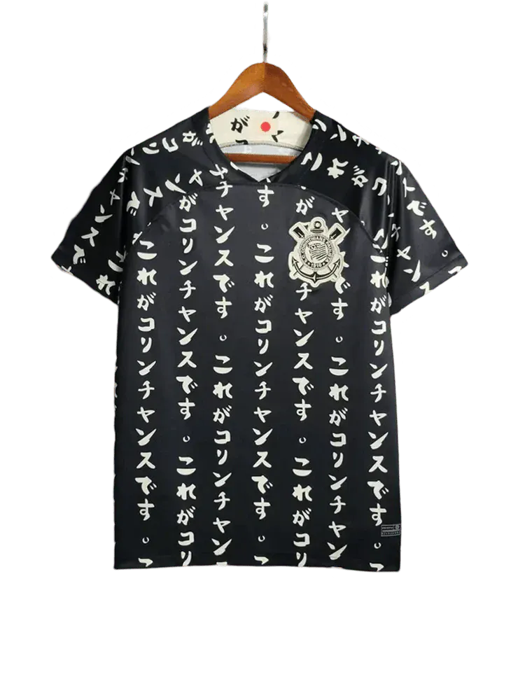 Corinthians 2022/23 third kit black front view with all-over white Japanese vertical text pattern, Corinthians crest on chest, black collar, typography football shirt