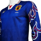 Blue sports jersey with flame designs on sleeves, featuring a logo and 'Japan' text.