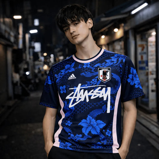 Blue Stussy Japan soccer jersey with dragon scale pattern and floral graphics worn by model front view