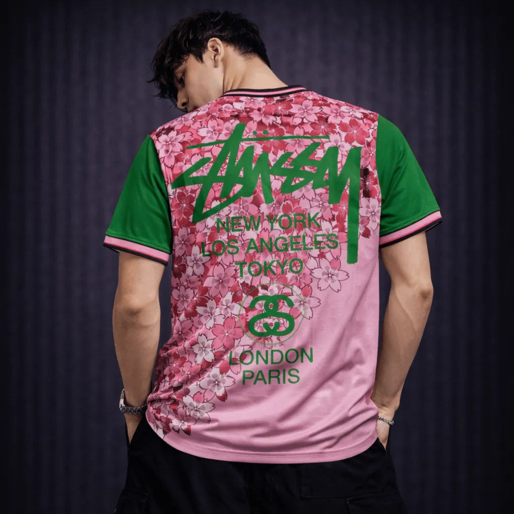 Back view pink Stussy Japan soccer jersey with city print