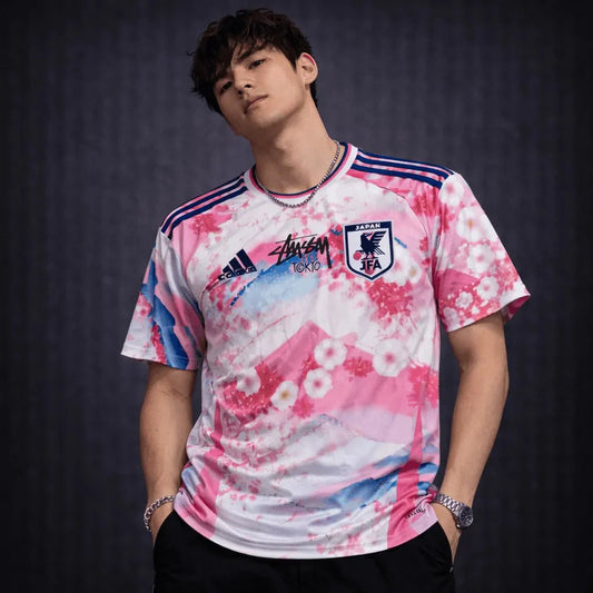Model wearing stussy japan soccer jersey with sakura blossom print